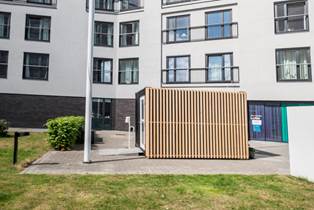 Lameller udvendigt på den smittesikre container giver den et moderne udtryk Corona-container beklædt med lameller