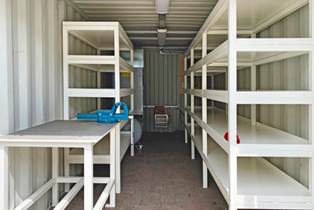 Containeren er indrettet med arbejdsbord, reoler og kompressor Container indrettet med arbejdsbord